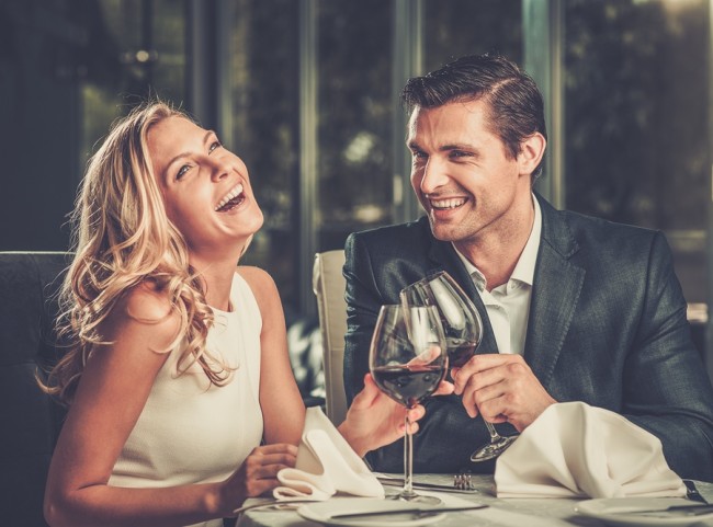 Cheerful couple in a restaurant with glasses of red wine